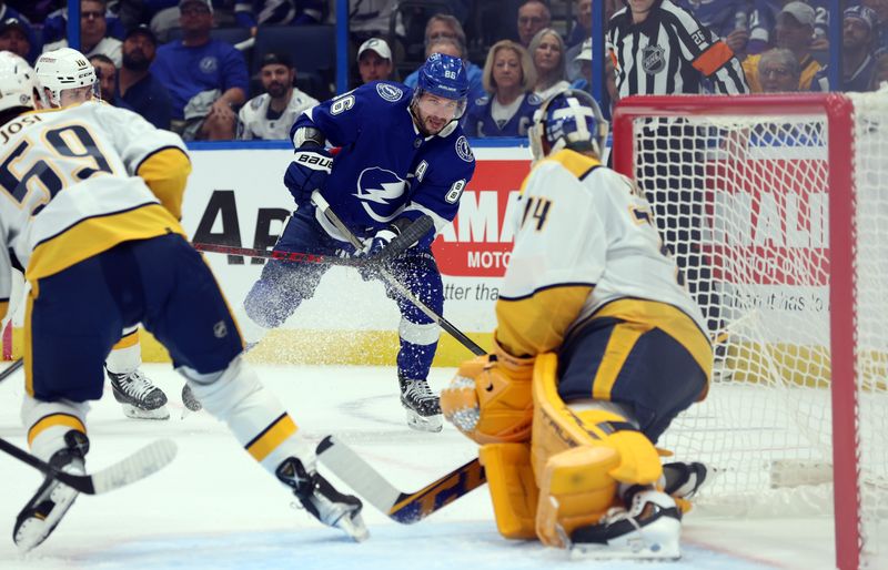 Oct 10, 2023; Tampa, Florida, USA;Tampa Bay Lightning right wing Nikita Kucherov (86) shoots as Nashville Predators goaltender Juuse Saros (74) defends during the first period at Amalie Arena. Mandatory Credit: Kim Klement Neitzel-USA TODAY Sports