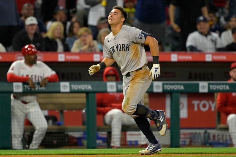 May 29, 2024; Anaheim, California, USA; New York Yankees shortstop Anthony Volpe (11) triples and then scored on a throwing error to third by Los Angeles Angels second baseman Luis Rengifo (2) in the seventh inning at Angel Stadium. Mandatory Credit: Jayne Kamin-Oncea-USA TODAY Sports