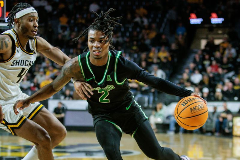 Jan 4, 2024; Wichita, Kansas, USA; North Texas Mean Green guard Jason Edwards (2) drives past Wichita State Shockers guard Colby Rogers (4) during the second half at Charles Koch Arena. Mandatory Credit: William Purnell-USA TODAY Sports