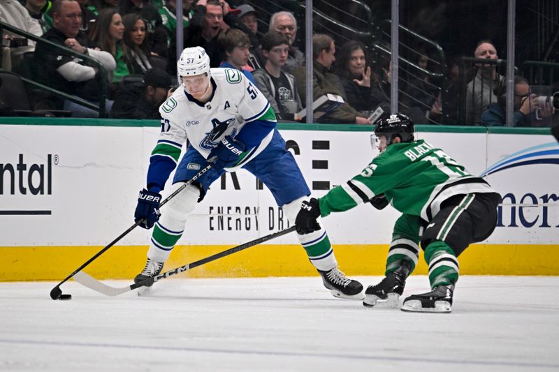 Jan 31, 2025; Dallas, Texas, USA; Vancouver Canucks defenseman Tyler Myers (57) passes the puck by Dallas Stars center Colin Blackwell (15) during the second period at the American Airlines Center. Mandatory Credit: Jerome Miron-Imagn Images