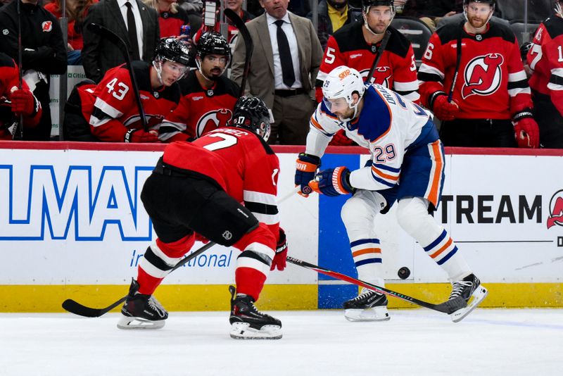 Oct 18, 2025; Newark, New Jersey, USA; Edmonton Oilers center Leon Draisaitl (29) skates with the puck while defended by New Jersey Devils defenseman Simon Nemec (17) during the first period at Prudential Center. Mandatory Credit: John Jones-Imagn Images