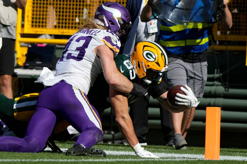 Green Bay Packers tight end Tucker Kraft (85) dives into the end zone for a touchdown past Minnesota Vikings outside linebacker Andrew Van Ginkel (43) during the second half of an NFL football game Sunday, Sept. 29, 2024, in Green Bay, Wis. (AP Photo/Morry Gash)