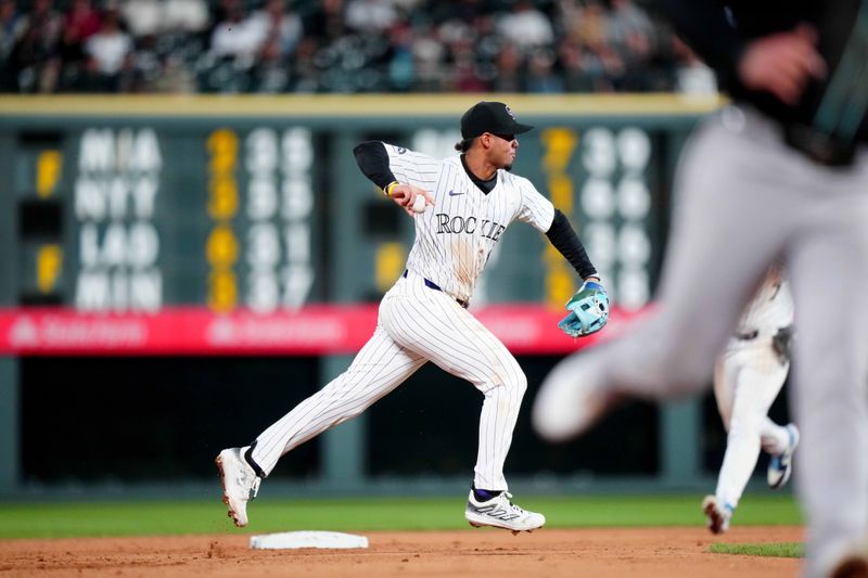 Apr 9, 2024; Denver, Colorado, USA; Colorado Rockies shortstop Ezequiel Tovar (14) fields the ball in the sixth inning against the Arizona Diamondbacks  at Coors Field. Mandatory Credit: Ron Chenoy-USA TODAY Sports