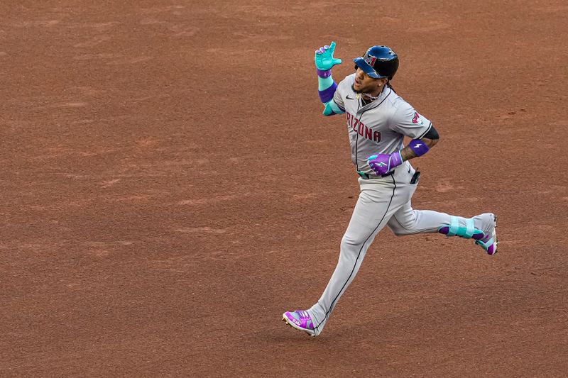 Apr 5, 2024; Cumberland, Georgia, USA; Arizona Diamondbacks second baseman Ketel Marte (4) reacts as he runs the bases after hitting a lead off home run against the Atlanta Braves during the first inning at Truist Park. Mandatory Credit: Dale Zanine-USA TODAY Sports