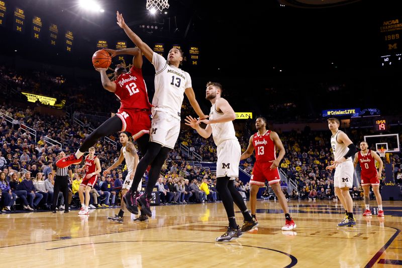 Feb 8, 2023; Ann Arbor, Michigan, USA;  Nebraska Cornhuskers guard Denim Dawson (12) shoots on Michigan Wolverines guard Jett Howard (13) in the second half at Crisler Center. Mandatory Credit: Rick Osentoski-USA TODAY Sports