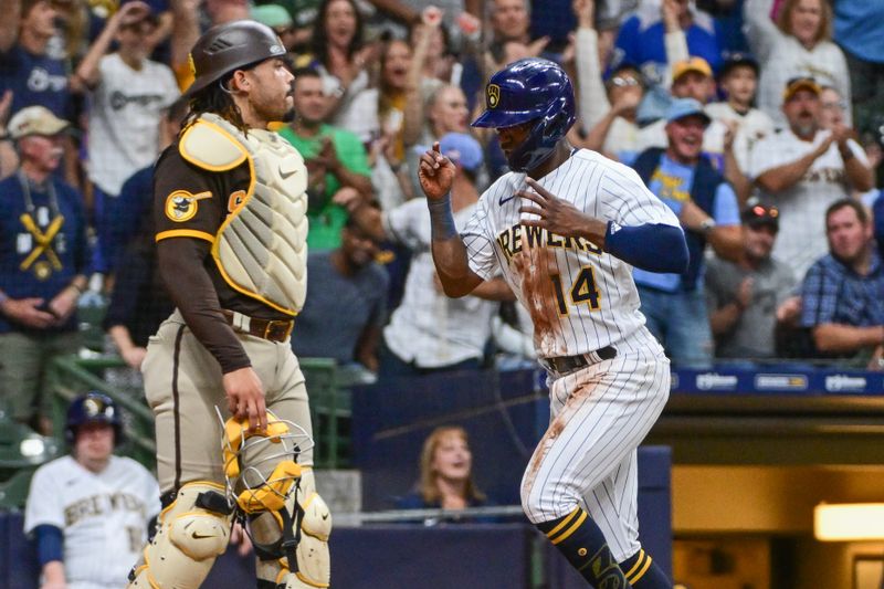 Aug 26, 2023; Milwaukee, Wisconsin, USA; Milwaukee Brewers third baseman Andruw Monasterio (14) scores a run after a stolen base and a throwing error by San Diego Padres catcher Luis Campusano (12) in the fifth inning at American Family Field. Mandatory Credit: Benny Sieu-USA TODAY Sports