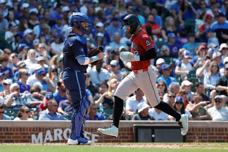 Jul 19, 2024; Chicago, Illinois, USA; Arizona Diamondbacks outfielder Lourdes Gurriel Jr. (12) scores against the Chicago Cubs during the fifth inning at Wrigley Field. Mandatory Credit: Kamil Krzaczynski-USA TODAY Sports