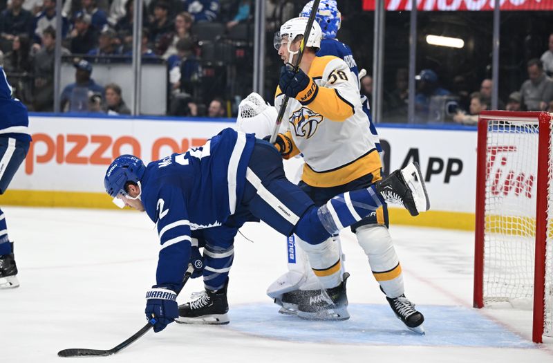 Oct 14, 2025; Toronto, Ontario, CAN;  Nashville Predators forward Michael Bunting (58) knocks over Toronto Maple Leafs defenseman Jake McCabe (22) in the second period at Scotiabank Arena. Mandatory Credit: Dan Hamilton-Imagn Images