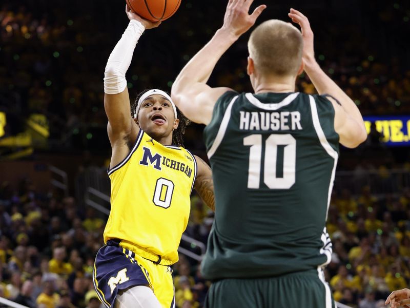 Feb 18, 2023; Ann Arbor, Michigan, USA;  Michigan Wolverines guard Dug McDaniel (0) shoots the ball over Michigan State Spartans forward Joey Hauser (10) in the first half at Crisler Center. Mandatory Credit: Rick Osentoski-USA TODAY Sports