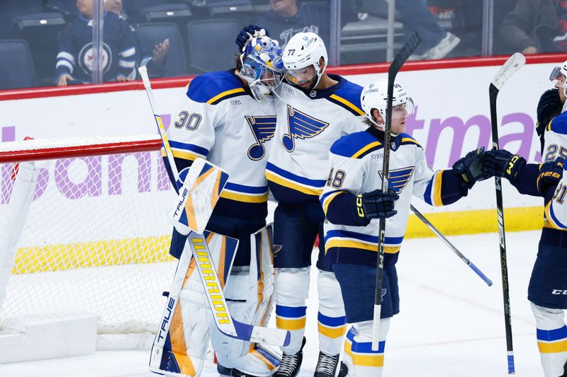 Dec 3, 2024; Winnipeg, Manitoba, CAN;  St. Louis Blues goalie Joel Hofer (30) is congratulated by St. Louis Blues defenseman Pierre-Olivier Joseph (77) on the win against the Winnipeg Jets at the end of the third period at Canada Life Centre. Mandatory Credit: Terrence Lee-Imagn Images