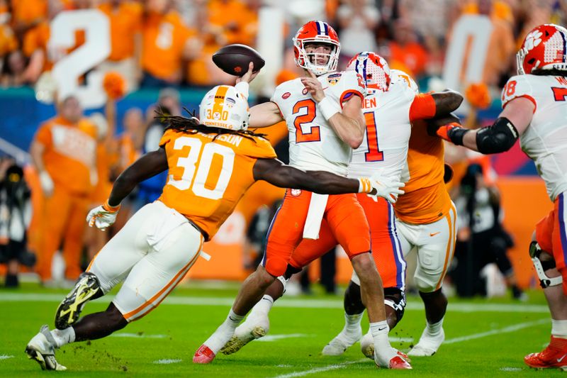 Dec 30, 2022; Miami Gardens, FL, USA; Clemson Tigers quarterback Cade Klubnik (2) throws a pass while pressured by Tennessee Volunteers defensive lineman Roman Harrison (30) during the first half of the 2022 Orange Bowl at Hard Rock Stadium. Mandatory Credit: Rich Storry-USA TODAY Sports