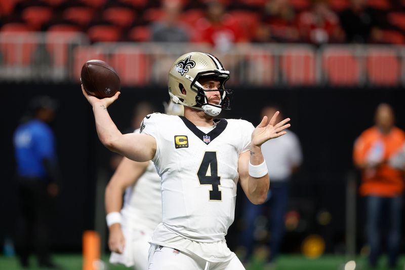 New Orleans Saints quarterback Derek Carr (4) warms up before an NFL football game against the Atlanta Falcons, Sunday, Sept. 29, 2024, in Atlanta. (AP Photo/Butch Dill)