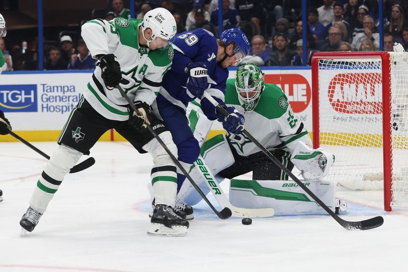 Oct 30, 2025; Tampa, Florida, USA; Tampa Bay Lightning center Jake Guentzel (59) shoots as Dallas Stars goaltender Jake Oettinger (29) and Dallas Stars defenseman Esa Lindell (23) defends during the third period at Benchmark International Arena. Mandatory Credit: Kim Klement Neitzel-Imagn Images
