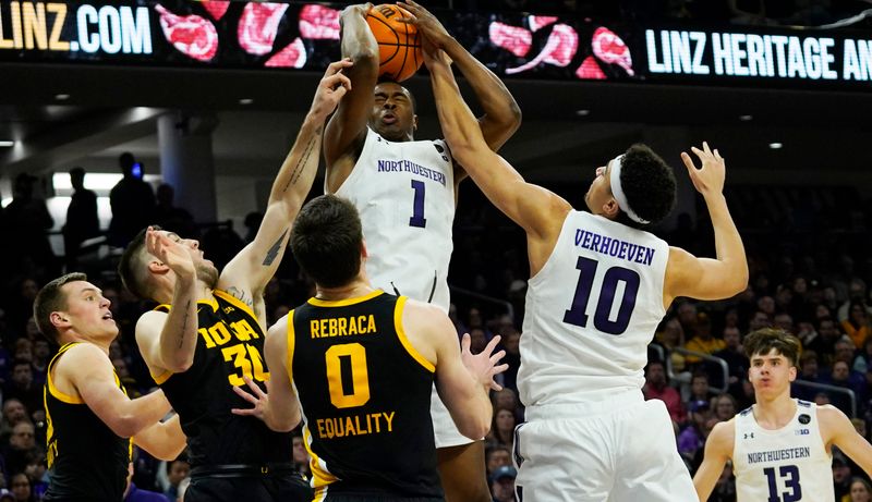 Feb 19, 2023; Evanston, Illinois, USA; Iowa Hawkeyes forward Payton Sandfort (left) guard Connor McCaffery (30) forward Filip Rebraca (0) defend Northwestern Wildcats guard Chase Audige (1) during the second half at Welsh-Ryan Arena. Mandatory Credit: David Banks-USA TODAY Sports