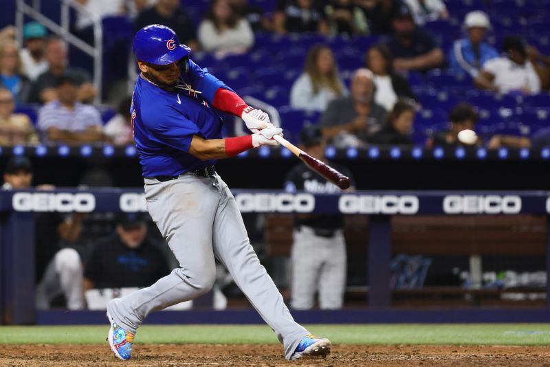 Aug 23, 2024; Miami, Florida, USA; Chicago Cubs third baseman Isaac Paredes (17) hits an RBI double against the Miami Marlins during the eighth inning at loanDepot Park. Mandatory Credit: Sam Navarro-USA TODAY Sports