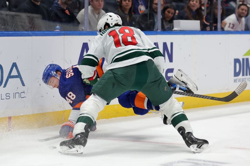 Nov 7, 2025; Elmont, New York, USA; New York Islanders defenseman Matthew Schaefer (48) fights for the puck against Minnesota Wild center Vinnie Hinostroza (18) during the first period at UBS Arena. Mandatory Credit: Brad Penner-Imagn Images