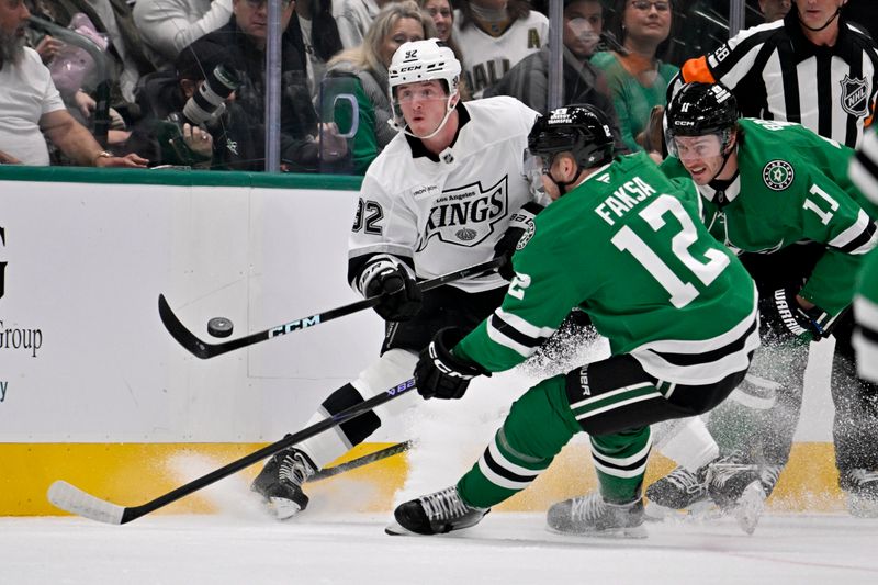Oct 23, 2025; Dallas, Texas, USA; Los Angeles Kings defenseman Brandt Clarke (92) clears the puck in front of Dallas Stars center Radek Faksa (12) and right wing Nathan Bastian (11) during the first period at the American Airlines Center. Mandatory Credit: Jerome Miron-Imagn Images