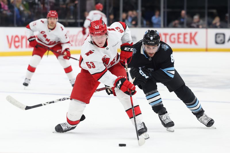 Nov 13, 2024; Salt Lake City, Utah, USA;Carolina Hurricanes right wing Jackson Blake (53) and Utah Hockey Club center Nick Schmaltz (8) battle for the puck during the first period  at Delta Center. Mandatory Credit: Rob Gray-Imagn Images