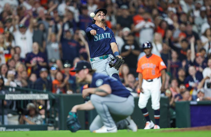 May 3, 2024; Houston, Texas, USA; Seattle Mariners third baseman Josh Rojas (4) attempts to throw out Houston Astros second baseman Jose Altuve (not pictured) on a play during the seventh inning at Minute Maid Park. Mandatory Credit: Troy Taormina-USA TODAY Sports