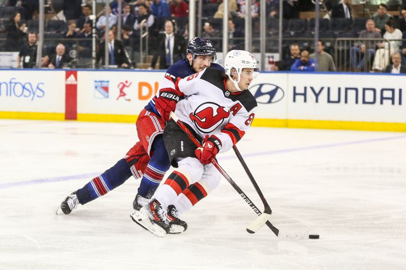 Apr 3, 2024; New York, New York, USA; New Jersey Devils center Jack Hughes (86) pushes the puck past New York Rangers defenseman Ryan Lindgren (55) in the second period at Madison Square Garden. Mandatory Credit: Wendell Cruz-USA TODAY Sports