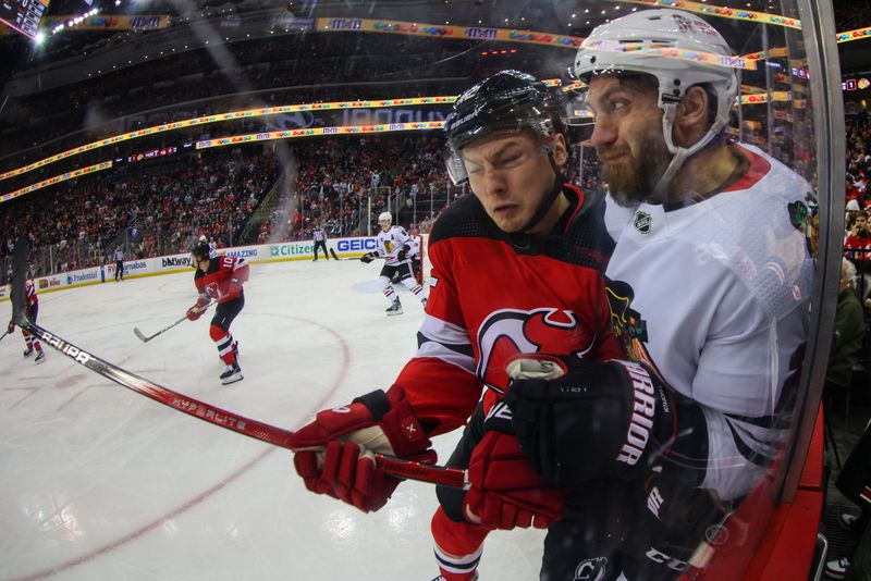 Jan 5, 2024; Newark, New Jersey, USA; New Jersey Devils center Curtis Lazar (42) hits Chicago Blackhawks defenseman Jarred Tinordi (25) during the second period at Prudential Center. Mandatory Credit: Ed Mulholland-USA TODAY Sports