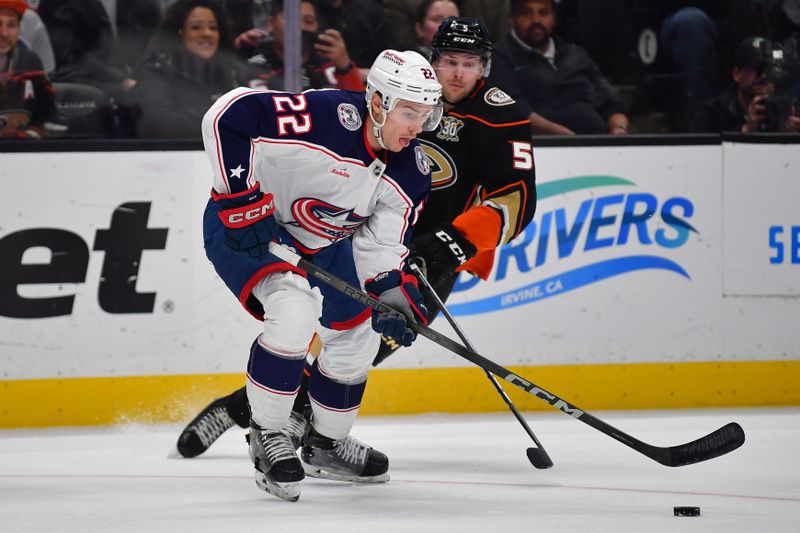 Feb 21, 2024; Anaheim, California, USA; Columbus Blue Jackets defenseman Jake Bean (22) moves the puck against Anaheim Ducks defenseman Urho Vaakanainen (5) during the first period at Honda Center. Mandatory Credit: Gary A. Vasquez-USA TODAY Sports