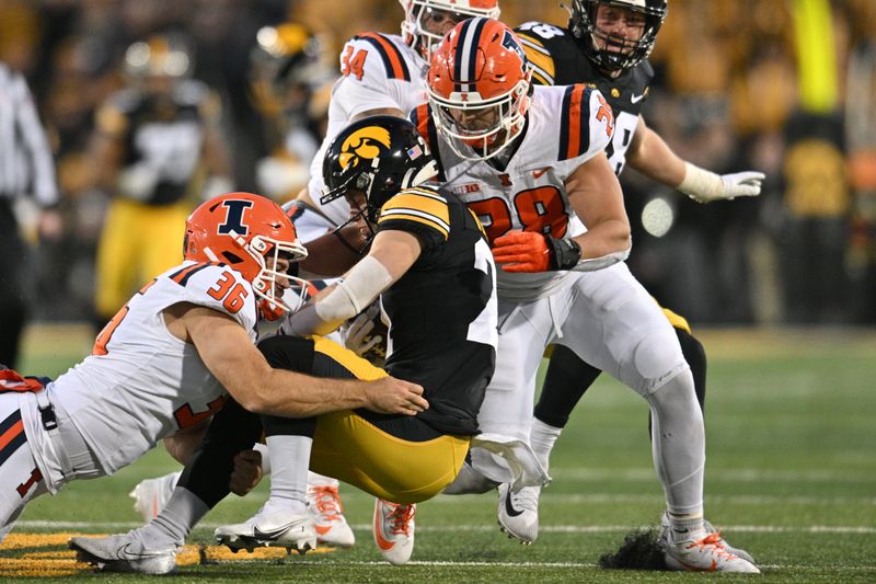 Nov 18, 2023; Iowa City, Iowa, USA; Iowa Hawkeyes kick returner Kaden Wetjen (21) is tackled by Illinois Fighting Illini tight end Ben Schultz (36) and linebacker Dylan Rosiek (28) during the third quarter at Kinnick Stadium. Mandatory Credit: Jeffrey Becker-USA TODAY Sports