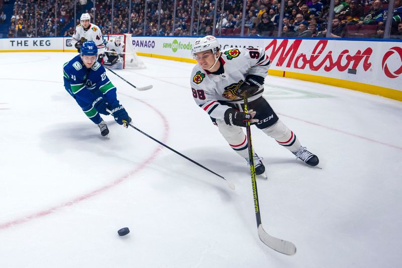 Nov 16, 2024; Vancouver, British Columbia, CAN; Vancouver Canucks forward Danton Heinen (20) and Chicago Blackhawks forward Connor Bedard (98) chase down a loose puck during the first period at Rogers Arena. Mandatory Credit: Bob Frid-Imagn Images