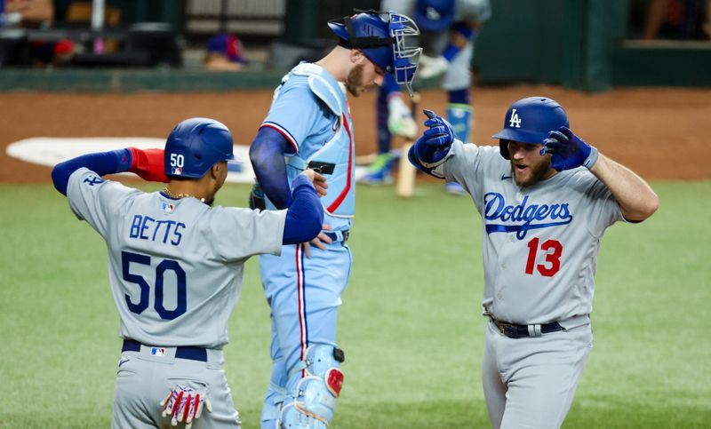 Jul 23, 2023; Arlington, Texas, USA;  Los Angeles Dodgers third baseman Max Muncy (13) celebrates with Los Angeles Dodgers second baseman Mookie Betts (50) in front of Texas Rangers catcher Jonah Heim (28) after hitting a grand slam during the first inning at Globe Life Field. Mandatory Credit: Kevin Jairaj-USA TODAY Sports