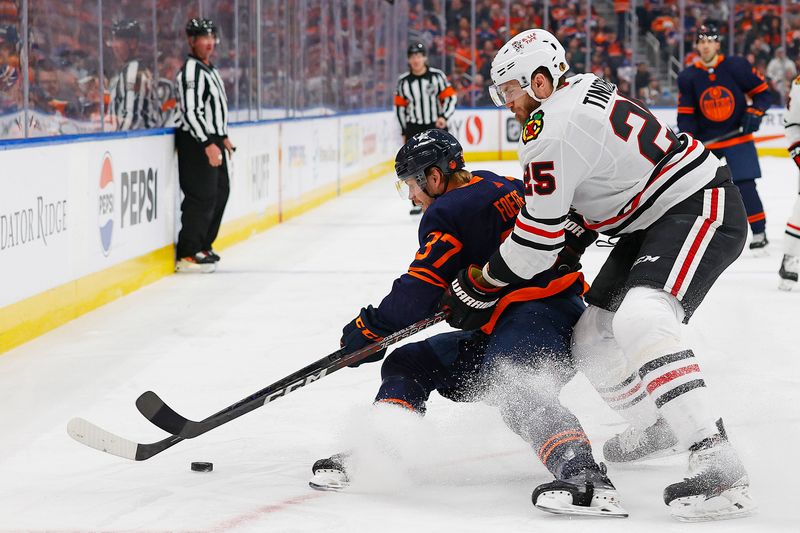 Jan 25, 2024; Edmonton, Alberta, CAN; Edmonton Oilers forward Warren Foegele (37) protects the puck from Chicago Blackhawks defensemen Jarred Tinordi (25) during the first period at Rogers Place. Mandatory Credit: Perry Nelson-USA TODAY Sports