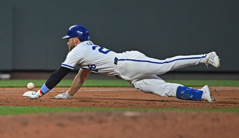 Jun 27, 2024; Kansas City, Missouri, USA;  Kansas City Royals center fielder Kyle Isbel (28) dives into third base with a lead off triple in the sixth inning against the Cleveland Guardians at Kauffman Stadium. Mandatory Credit: Peter Aiken-USA TODAY Sports