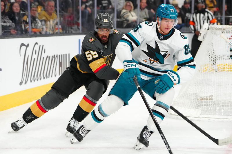 Nov 29, 2025; Las Vegas, Nevada, USA; San Jose Sharks defenseman Shakir Mukhamadullin (85) skates ahead of Vegas Golden Knights right wing Keegan Kolesar (55) during the first period at T-Mobile Arena. Mandatory Credit: Stephen R. Sylvanie-Imagn Images