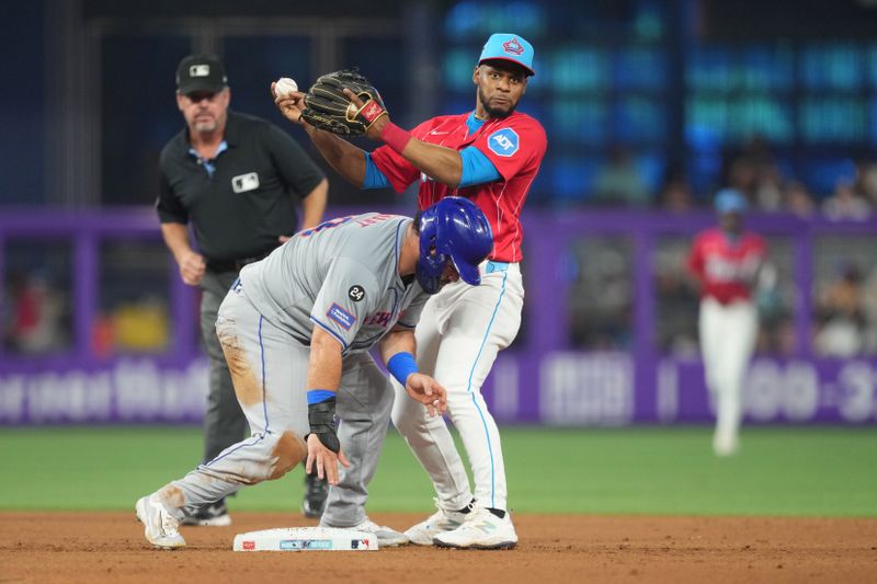 Jul 20, 2024; Miami, Florida, USA;  Miami Marlins second baseman Otto Lopez (61) holds the ball after forcing out New York Mets right fielder DJ Stewart (29) at second base in the fourth inning the at loanDepot Park. Mandatory Credit: Jim Rassol-USA TODAY Sports