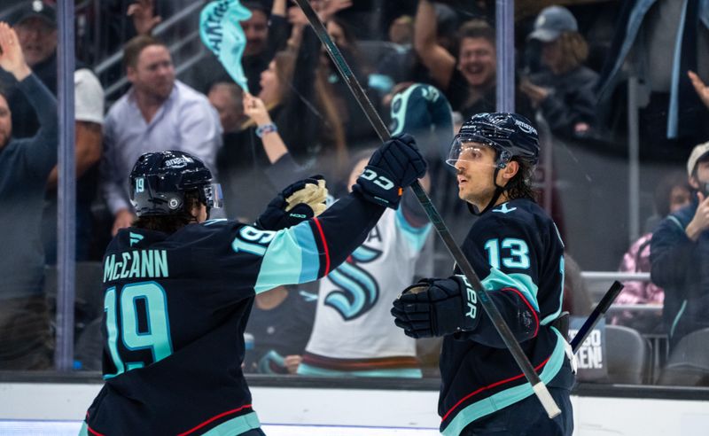 Nov 14, 2024; Seattle, Washington, USA;  Seattle Kraken forward Brandon Tanev (13) is congratulated by forward Jared McCann (19) after scoring an empty-net goal during the third period against the Chicago Blackhawks at Climate Pledge Arena. Mandatory Credit: Stephen Brashear-Imagn Images