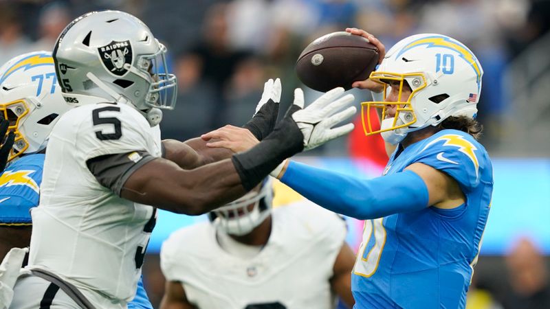 Los Angeles Chargers quarterback Justin Herbert (10) throws under pressure from Las Vegas Raiders linebacker Divine Deablo during the first half of an NFL football game Sunday, Oct. 1, 2023, in Inglewood, Calif. (AP Photo/Ryan Sun)