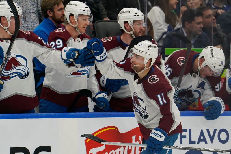 Jan 13, 2024; Toronto, Ontario, CAN; Colorado Avalanche forward Andrew Cogliano (11) gets congratulated after scoring against the Toronto Maple Leafs during the third period at Scotiabank Arena. Mandatory Credit: John E. Sokolowski-USA TODAY Sports