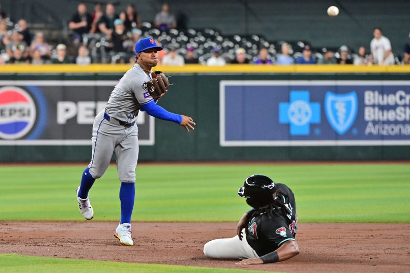 Aug 29, 2024; Phoenix, Arizona, USA;  New York Mets shortstop Francisco Lindor (12) turns a double play on Arizona Diamondbacks first base Josh Bell (36) in the second inning at Chase Field. Mandatory Credit: Matt Kartozian-USA TODAY Sports