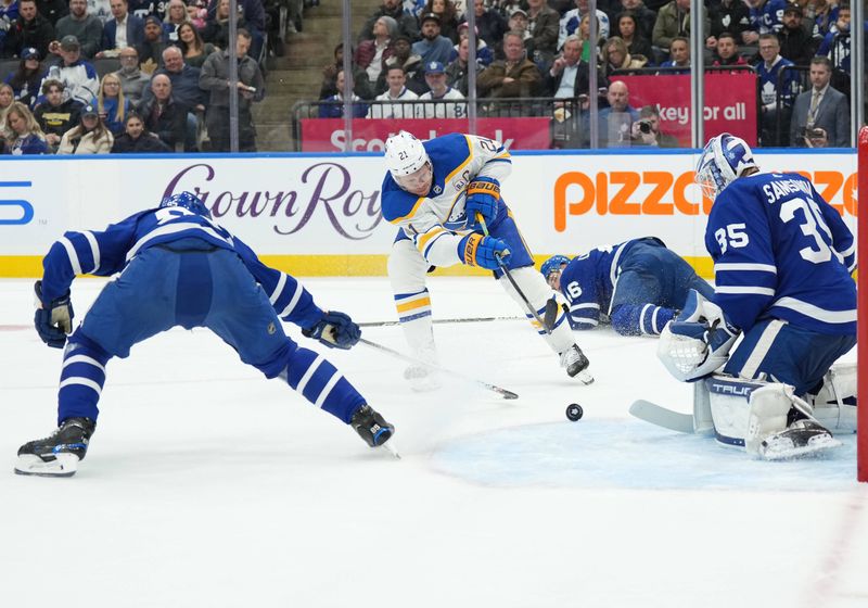 Mar 6, 2024; Toronto, Ontario, CAN; Buffalo Sabres right wing Kyle Okposo (21) battles for the puck with Toronto Maple Leafs defenseman William Lagesson (85) in front of Buffalo Sabres goaltender Ukko-Pekka Luukkonen (1) during the second period at Scotiabank Arena. Mandatory Credit: Nick Turchiaro-USA TODAY Sports