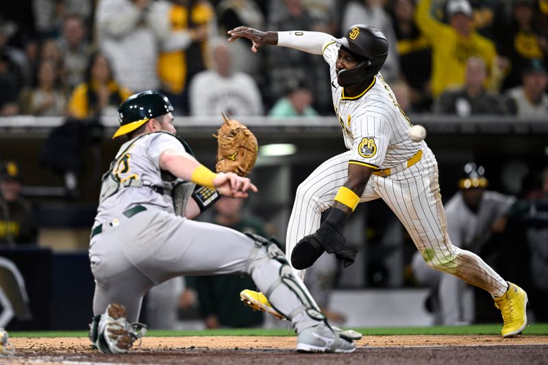 Jun 11, 2024; San Diego, California, USA; San Diego Padres left fielder Jurickson Profar (10) is tagged out at home by Oakland Athletics catcher Kyle McCann (52) during the fifth inning at Petco Park. Mandatory Credit: Orlando Ramirez-USA TODAY Sports