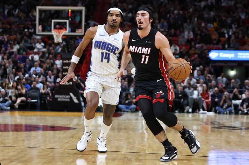 MIAMI, FLORIDA - FEBRUARY 06: Jaime Jaquez Jr. #11 of the Miami Heat drives past Gary Harris #14 of the Orlando Magic during the fourth quarter at Kaseya Center on February 06, 2024 in Miami, Florida. NOTE TO USER: User expressly acknowledges and agrees that, by downloading and or using this photograph, User is consenting to the terms and conditions of the Getty Images License Agreement. (Photo by Megan Briggs/Getty Images)