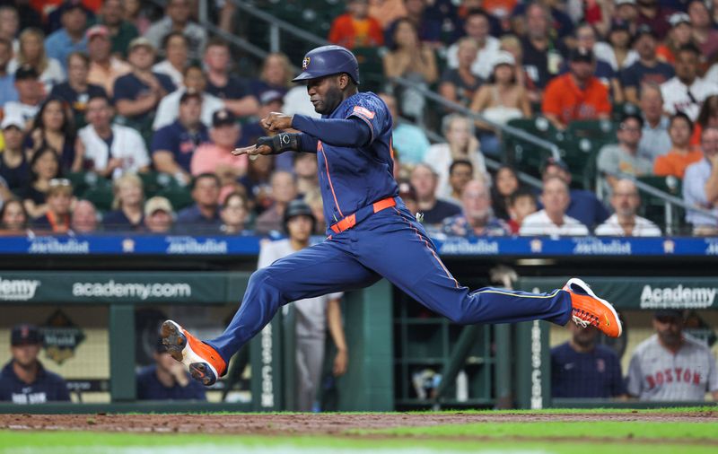 Aug 19, 2024; Houston, Texas, USA; Houston Astros designated hitter Yordan Alvarez (44) slides into home plate on a play during the fourth inning against the Boston Red Sox at Minute Maid Park. Mandatory Credit: Troy Taormina-USA TODAY Sports