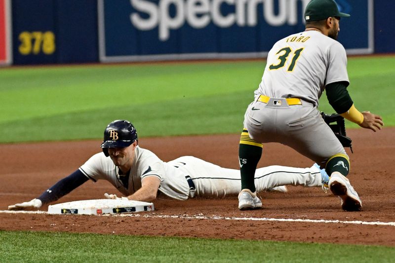 May 29, 2024; St. Petersburg, Florida, USA; Tampa Bay Rays second baseman Brandon Lowe (8) slides into third base with a RBI triple  in the fourth inning against the Oakland Athletics  at Tropicana Field. Mandatory Credit: Jonathan Dyer-USA TODAY Sports