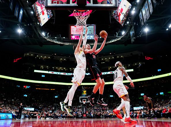 TORONTO, ON - DECEMBER 23: Jakob Poeltl #19 of the Toronto Raptors goes to the basket against the Utah Jazz during the second half of their basketball game at the Scotiabank Arena on December 23, 2023 in Toronto, Ontario, Canada. NOTE TO USER: User expressly acknowledges and agrees that, by downloading and/or using this Photograph, user is consenting to the terms and conditions of the Getty Images License Agreement. (Photo by Mark Blinch/Getty Images)