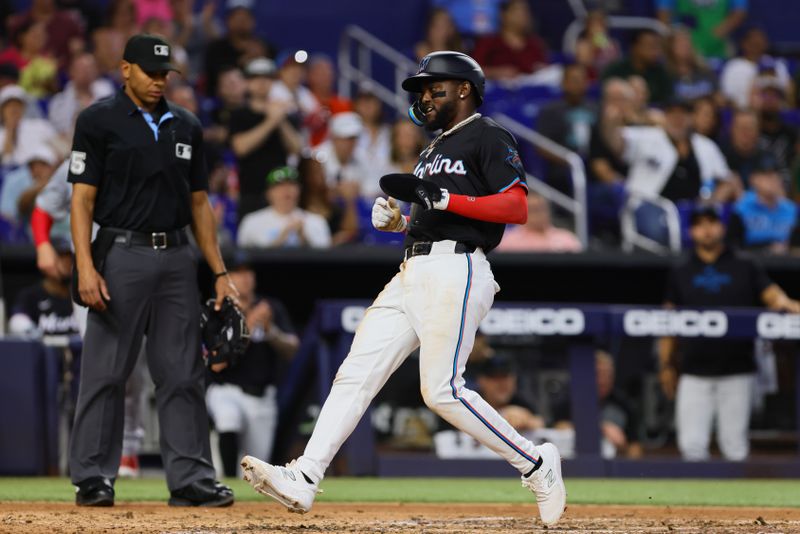 Apr 26, 2024; Miami, Florida, USA; Miami Marlins third baseman Vidal Brujan (17) scores against the Washington Nationals during the third inning at loanDepot Park. Mandatory Credit: Sam Navarro-USA TODAY Sports