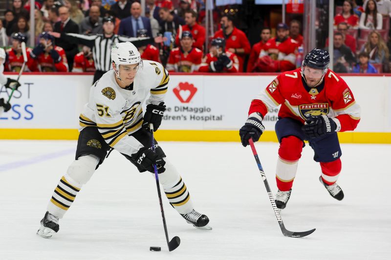 Nov 22, 2023; Sunrise, Florida, USA; Boston Bruins center Matthew Poitras (51) moves the puck against Florida Panthers defenseman Dmitry Kulikov (7) during the first period at Amerant Bank Arena. Mandatory Credit: Sam Navarro-USA TODAY Sports