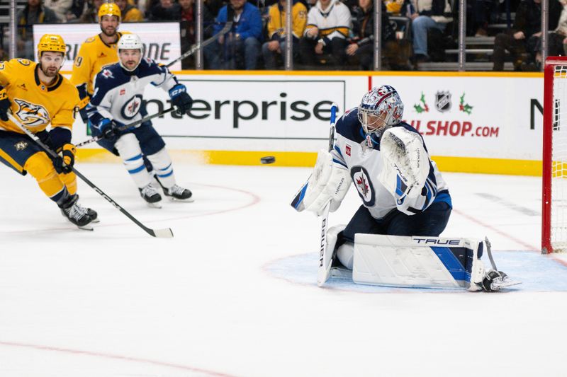 Nov 23, 2024; Nashville, Tennessee, USA;  Winnipeg Jets goaltender Eric Comrie (1) makes a glove save against the Nashville Predators during the third period at Bridgestone Arena. Mandatory Credit: Steve Roberts-Imagn Images