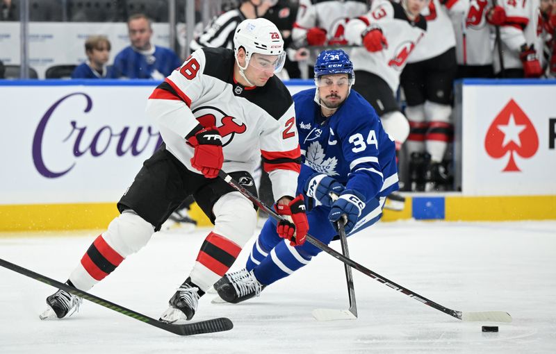 Jan 16, 2025; Toronto, Ontario, CAN;  New Jersey Devils forward Timo Meier (28) moves the puck past Toronto Maple Leafs forward Auston Matthews (34) in the second period at Scotiabank Arena. Mandatory Credit: Dan Hamilton-Imagn Images