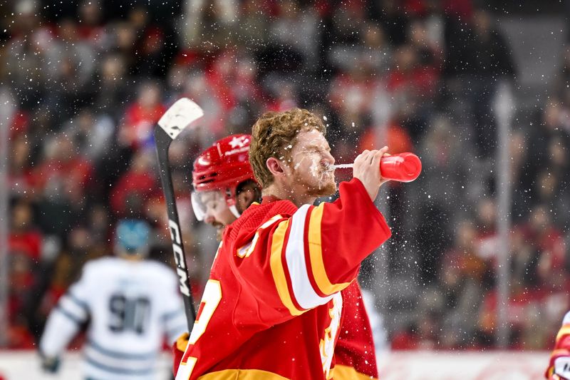 Feb 15, 2024; Calgary, Alberta, CAN; Calgary Flames goaltender Dustin Wolf (32) sprays his face with water during the first period of a game against the San Jose Sharks at Scotiabank Saddledome. Mandatory Credit: Brett Holmes-USA TODAY Sports