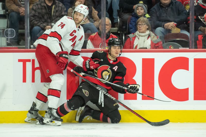 Dec 12, 2023; Ottawa, Ontario, CAN; Carolina Hurricanes defenseman Jacob Slavin (74) takes down Ottawa Senators center Tim Stutzle (18) in the first period at the Canadian Tire Centre. Mandatory Credit: Marc DesRosiers-USA TODAY Sports