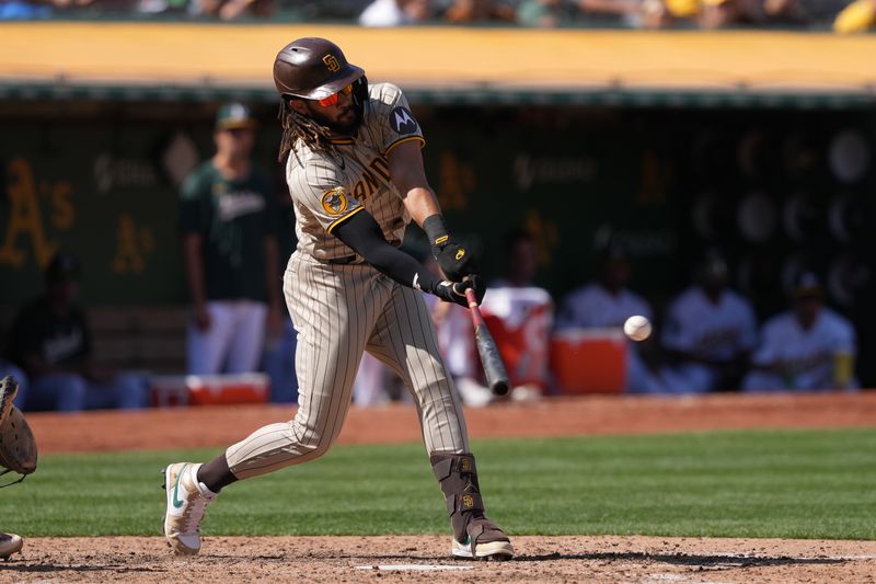 Sep 17, 2023; Oakland, California, USA; San Diego Padres right fielder Fernando Tatis Jr. (23) hits a single against the Oakland Athletics during the seventh inning at Oakland-Alameda County Coliseum. Mandatory Credit: Darren Yamashita-USA TODAY Sports